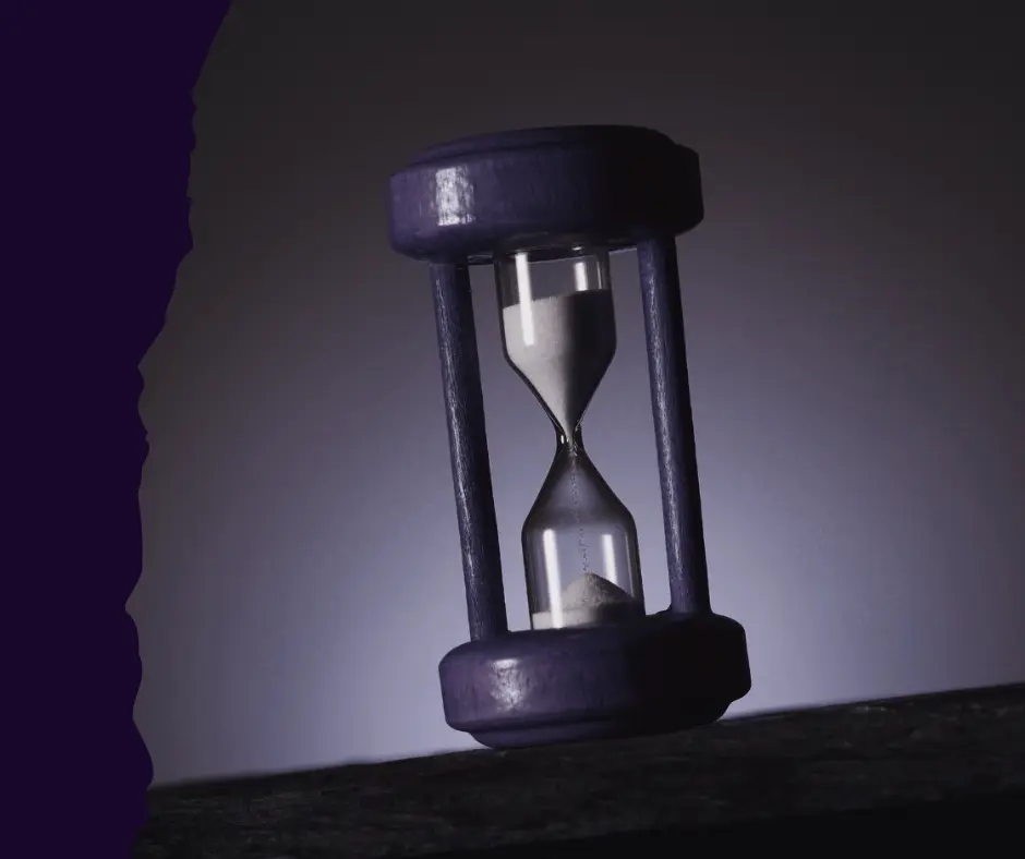 A minimalist purple hourglass with white sand flowing through, symbolizing time reclamation and nervous system regulation.