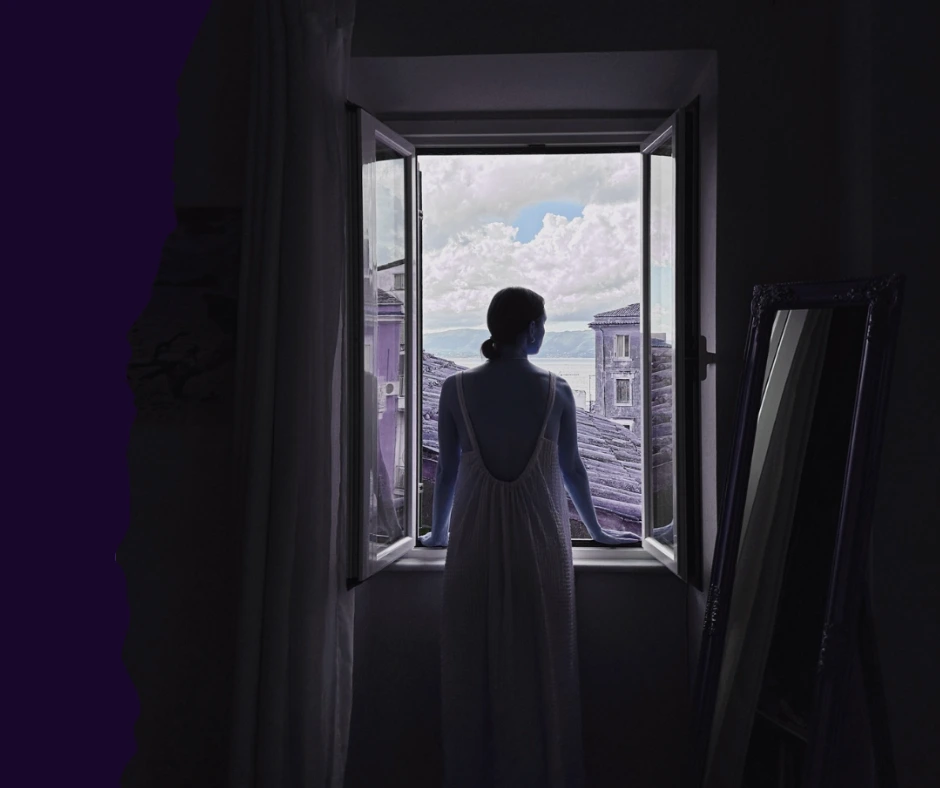 Silhouette of a woman looking out an open window toward a coastal town, reflecting a sense of introspection and listening to internal body signals.