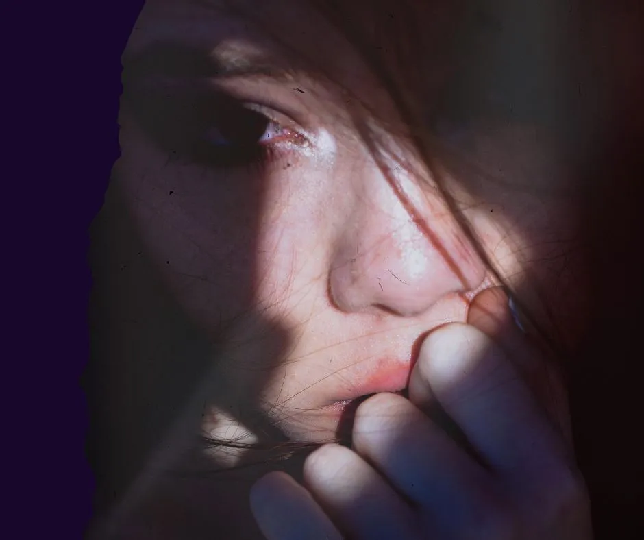 Close-up of a thoughtful woman in shadow reflecting on emotional transformation and midlife awakening.