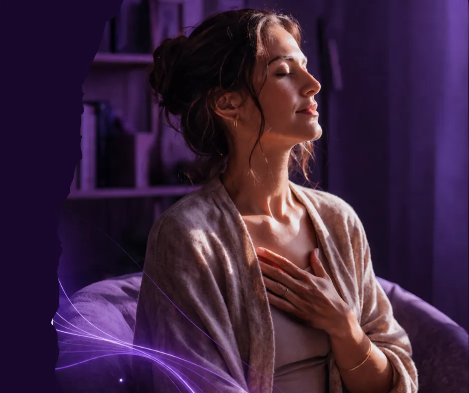 Woman practicing calm breathing in a purple toned room representing nervous system healing and emotional regulation